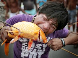 PROTESTNÍ ZAHRYZNUTÍ. Jeden z brazislkých demonstrant se zakusuje do ryby...