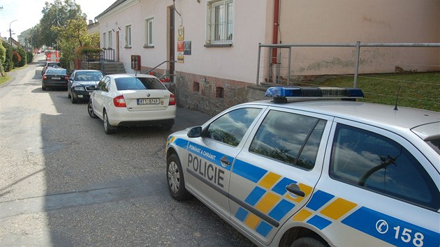 Policejní auta před budou pošty a obecního úřadu ve Skřipově na Opavsku, kde našli zavražděnou pošťačku. (1. října 2013)