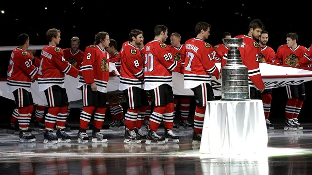 SLAVNOSTN CEREMONIL. Hokejist Chicaga coby obhjci Stanley Cupu ukzali na startu nov sezony trofej fanoukm. 