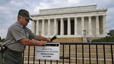 Richard Trott upevňuje ceduli oznamující uzavření Lincolnova památníku ve