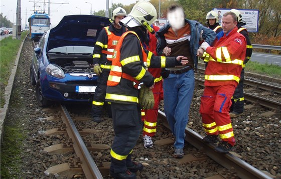 Záchranái a hasii odvádjí zranného idie Fiatu Punto. (14. íjna 2013)