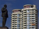 Newly built apartment blocks are seen near a statue of Vladimir Lenin in...
