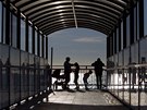 People enjoy the view from a pedestrian overpass near the beach in the Adler...