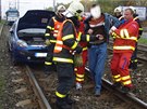 Záchranái a hasii odvádjí zranného idie Fiatu Punto. (14. íjna 2013)