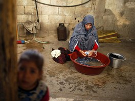 Newly married Tala Soboh, 14, washes clothes at the home of her 15-year-old...