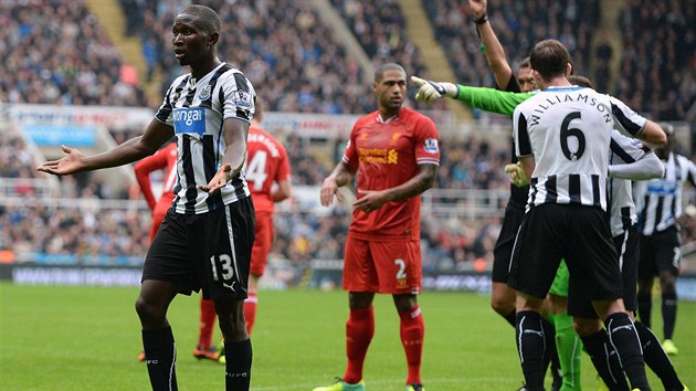 A VEN! Mapou Yanga-Mbiwa (vlevo) z Newcastle United dostv ervenou kartu po faulu na liverpoolskho Luise Suarze.