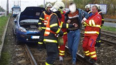 Záchranái a hasii odvádjí zranného idie Fiatu Punto. (14. íjna 2013)