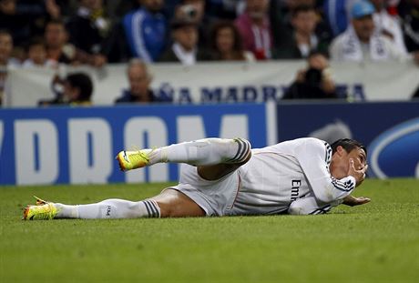 Útoník Cristiano Ronaldo z Realu Madrid se svíjí na zemi a drí se za obliej....