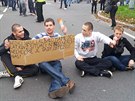 Nkteí z demonstrant se na protest proti zablokování prvodu posadili na...