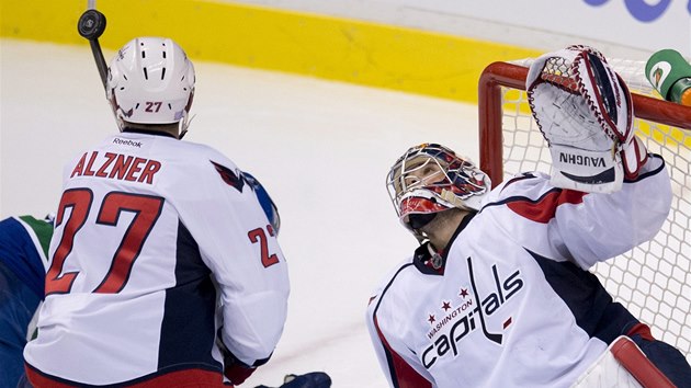 Brank Washingtonu Michal Neuvirth a jeho spoluhr Karl Alzner vyhlej puk. 