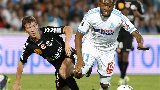 TVRD DOPAD. Jordan Ayew (vpravo) z Marseille neustl stet s Franckem Signorinem z Remee.