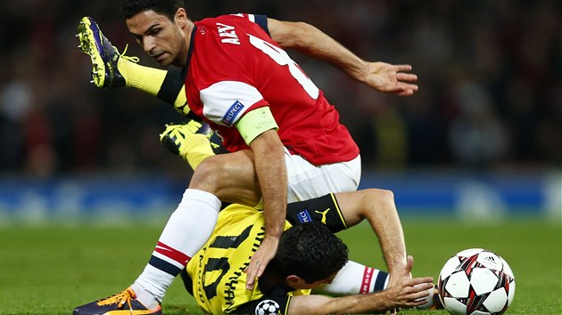 FAUL? Mchitarjan z Dortmundu kon na zemi po zkroku Artety z Arsenalu.