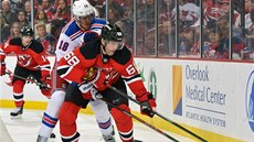 Jaromír Jágr (v pop�edí) z New Jersey bojuje o puk s  Marcem Staalem z New York