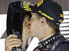 VÍTZNÝ POLIBEK. Sebastian Vettel líbá trofej pro vítze Velké ceny Abú Zabí.