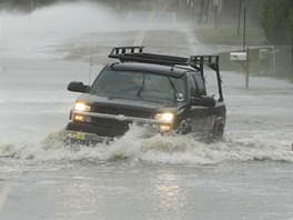 Auto projídí skrze zaplavenou cestu bhem hurikánu a pohled na stejnou silnici...