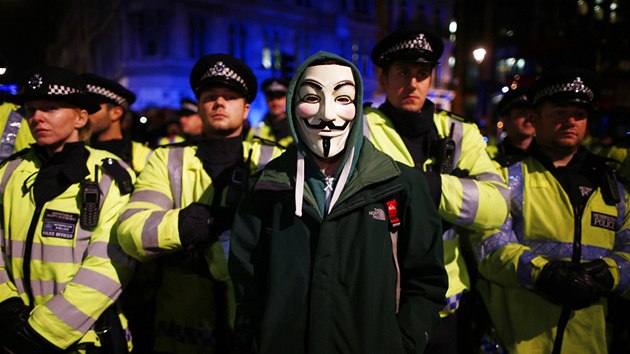 Londnt policist se stetli s demonstranty v maskch Guye Fawkese pi protestech proti rozpotovm krtm. (5. listopadu 2013)