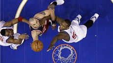 Marcin Gortat z Washingtonu mezi bránícími soupei z Philadelphie. Vlevo je