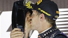 VÍTĚZNÝ POLIBEK. Sebastian Vettel líbá trofej pro vítěze Velké ceny Abú Zabí.