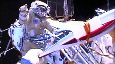 Na snímků NASA drží pochodeň ve vesmíru u ISS Oleg Kotov,  prstem ukazuje druhý...