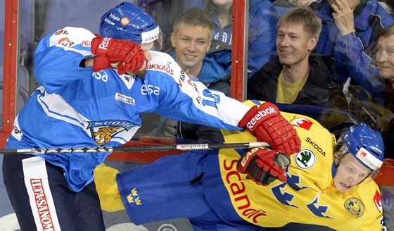 Jere Karalahti (vlevo) z Finska posílá k ledu Joela Lundqvista ze védska.