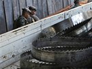 Soldiers from the Brazilian Army stand near a truck loaded with blades which...