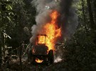 A tractor used to drag logs out of the Amazon rainforest, burns after being...