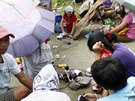 Lidé v Taclobanu si nabíjejí telefony díky nataené prodluovace.