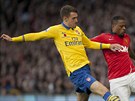 Patrice Evra (vpravo) z Manchesteru United uniká Aaronu Ramseymu z Arsenalu.