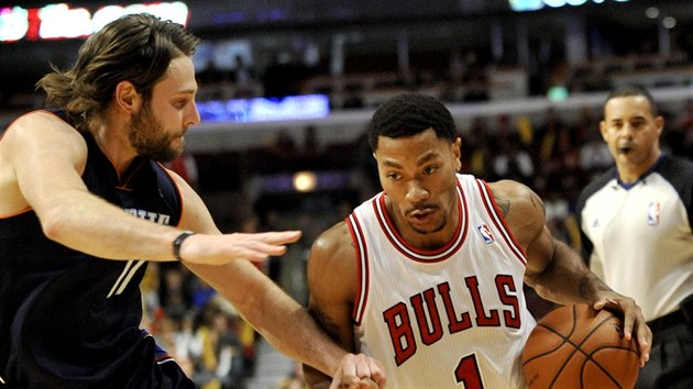 Derrick Rose (1) z Chicaga unik kolem Joshe McRobertse z Charlotte.