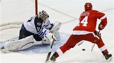 Branká Ondej Pavelec z Winnipegu likviduje nájezd Todda Bertuzziho z Detroitu.