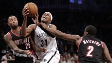 Paul Pierce z Brooklynu proniká mezi portlandskými Mo Williamsem (25) a...