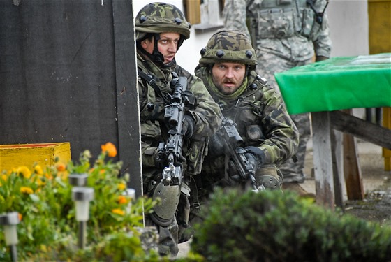 České jednotky pročesávají dobytou vesnici během cvičení Sabre Junction II v