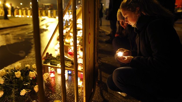 Lid pichzej k troskm zcenho nkupnho centra v Rize, aby tam zaplili svky nebo poloili kvtiny (22. listopadu 2013).