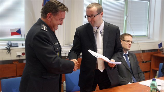 Ředitel policie ve Zlínském kraji Bedřich Koutný (vlevo) předává státnímu zástupci Romanu Kafkovi spis s návrhem na podání obžaloby.