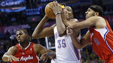 Kevin Durant z Oklahoma City proniká mezi Chrisem Paulem (vlevo) a Jaredem...