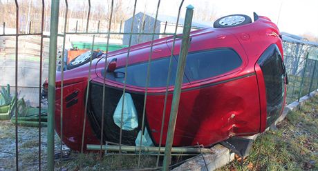 Peugeot 206 prorazil plot a skonil na levém boku. (17. prosince 2013)