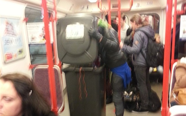Pán s popelnicí jede metrem.