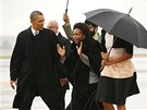Americký prezident Barack Obama s manelkou Michelle (schovaná pod detníkem)