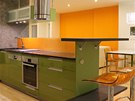 Zelená a oranová barva se v kuchyni opakují.