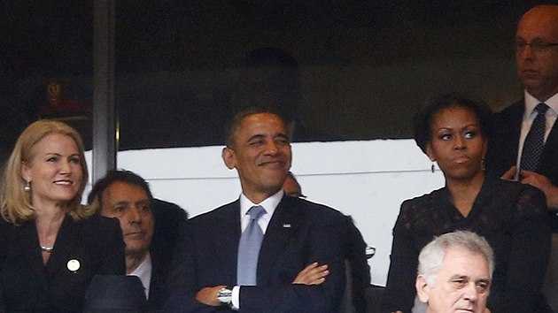 D�nsk� premi�rka Helle Thorning-Schmidtov� a americk� prezident Barack Obama se sm�j�, zat�mco Michelle Obamov� se netv��� vesele p�i smute�n� ceremonii Nelsona Mandely (10. prosince 2013)