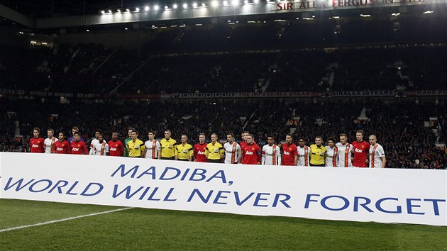 NIKDY NEZAPOMENEME. Fotbalisté Manchesteru United a Šachtaru Doněck před transparentem na památku zesnulého Nelsona Mandely: "Svět nikdy nezapomene."