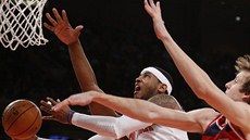 Carmelo Anthony zakonuje zleva na nj vak dotírá Kevin Seraphin, zprava Jan