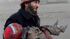 Mu v syrském mst Aleppo svírá v náruí dít, které zemelo pi útoku...