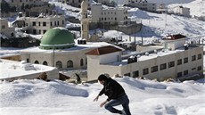 Palestinec se brodí snhem ve mst Náblus na Západním behu Jordánu.