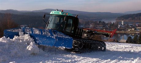 Rolba rozhrnuje sníh v horní ásti sjezdovky ve Frymburku, kde v pátek zahájí