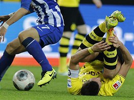 NA ZEMI. Sebastian Kehl z Dortmundu zstal leet na trávníku po stetu s...