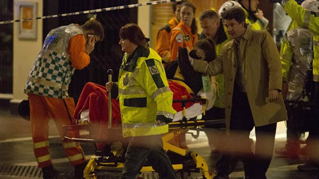 Zchrani odvej jednoho ze zrannch lid po pdu sti stropu v londnskm divadle Apollo (19. prosince 2013).