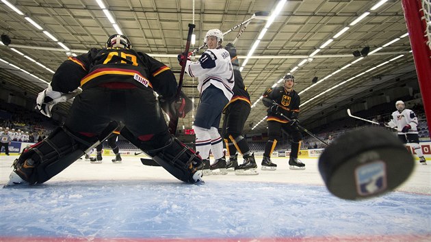 A JE TAM. Nmeck glman Patrick Klein musel bhem duelu proti USA lovit puk ze st celkem osmkrt, na snmku pesn pl tonk Ryan Hartman (s slem 21).