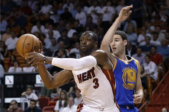 Dwyane Wade z Miami pihrává, za ním je Klay Thompson z Golden State.