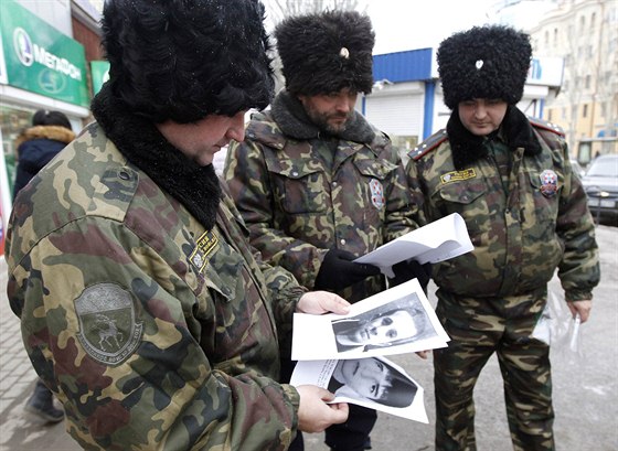 Rutí policisté prohlíejí portréty lidí podezelých z terorismu (Volgograd, 2....